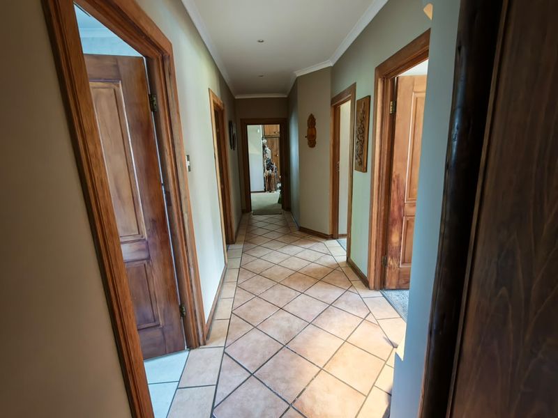 A well-lit hallway featuring tiled flooring and classic wooden door frames, providing access to multiple rooms within the home.