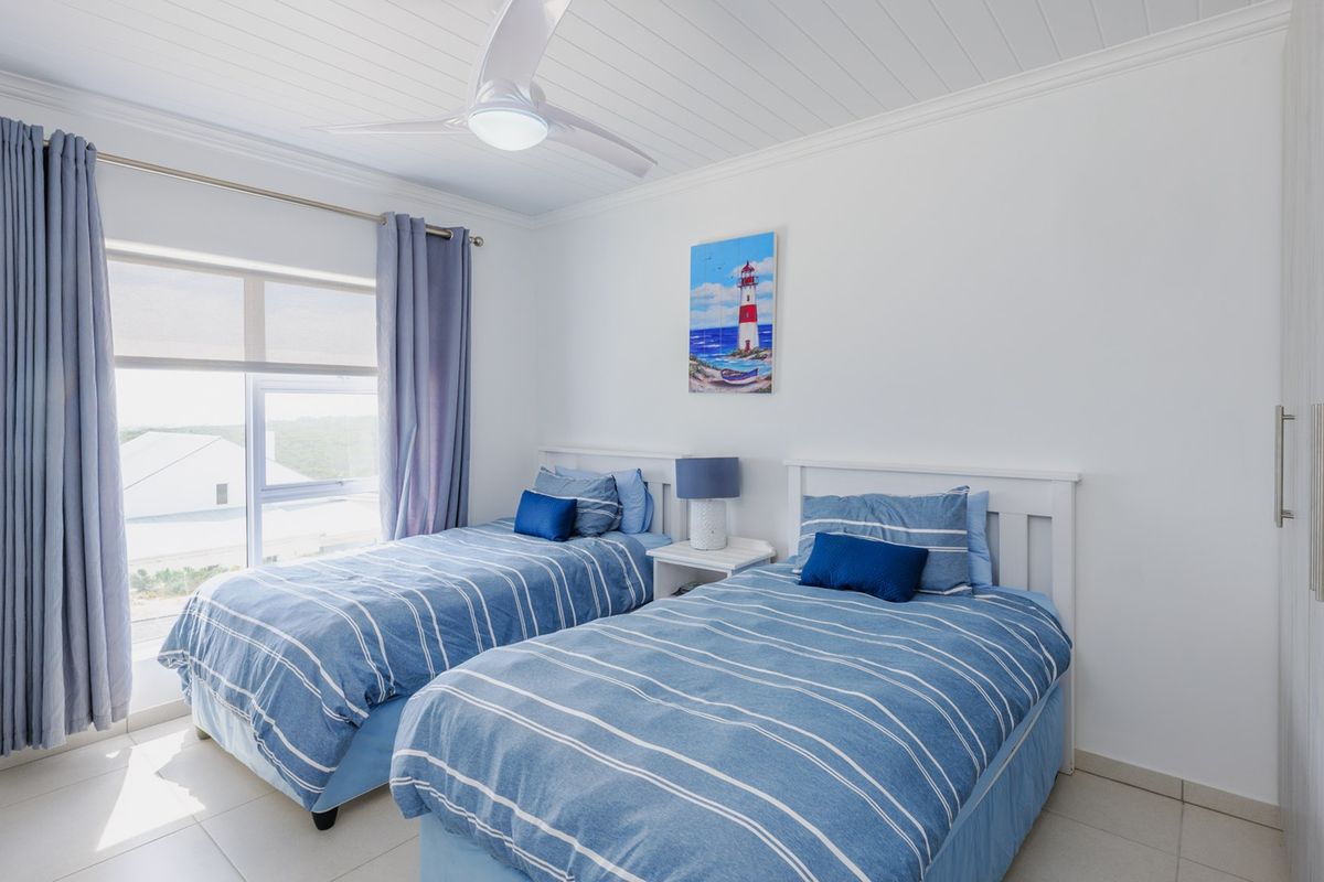 A bright and well-maintained bedroom featuring tiled floors, a ceiling fan, and built-in wardrobe storage.