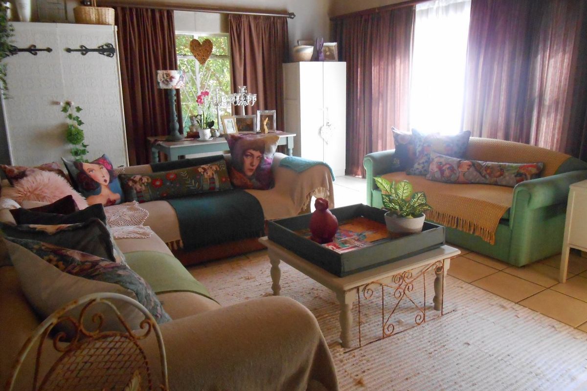 A comfortable living room featuring tiled flooring and large windows with curtain treatments, offering a bright and functional space for relaxation.