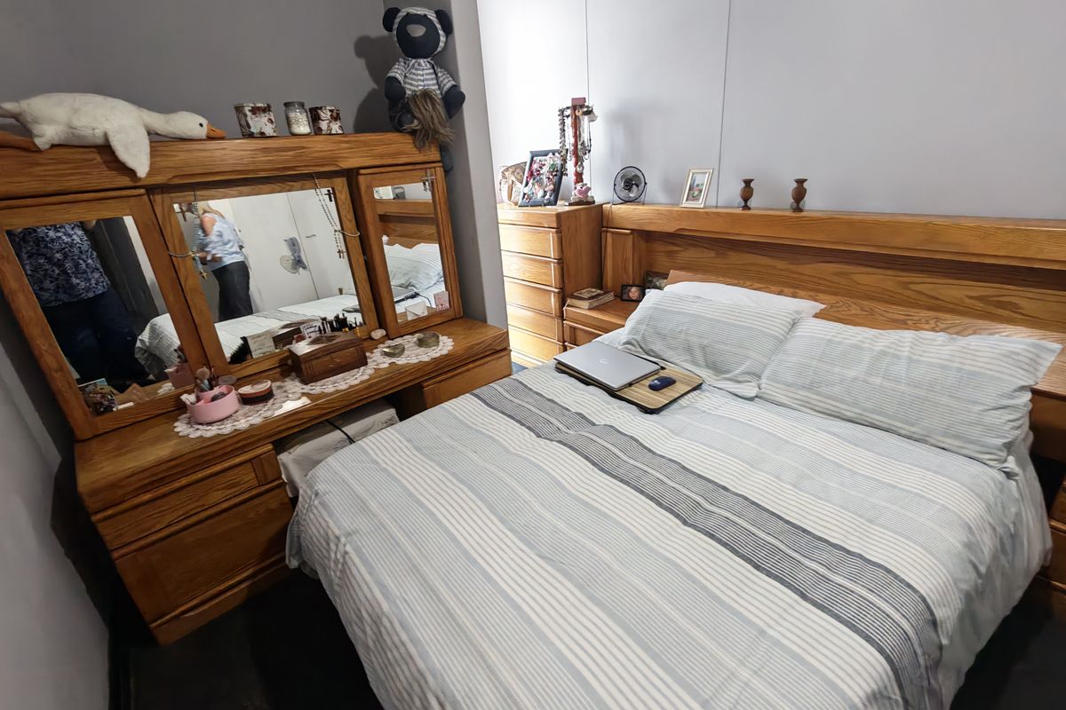 A standard bedroom featuring neutral wall finishes and space for a double bed and vanity unit.