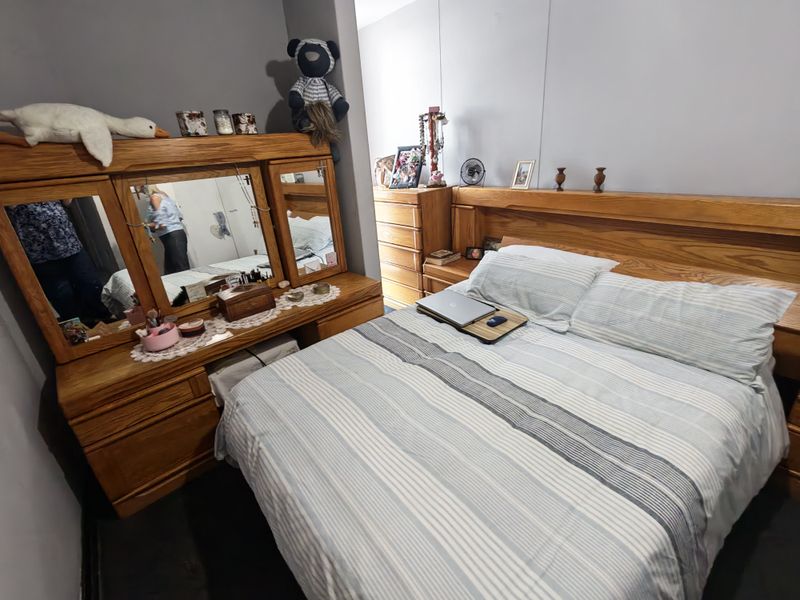 A standard bedroom featuring neutral wall finishes and space for a double bed and vanity unit.