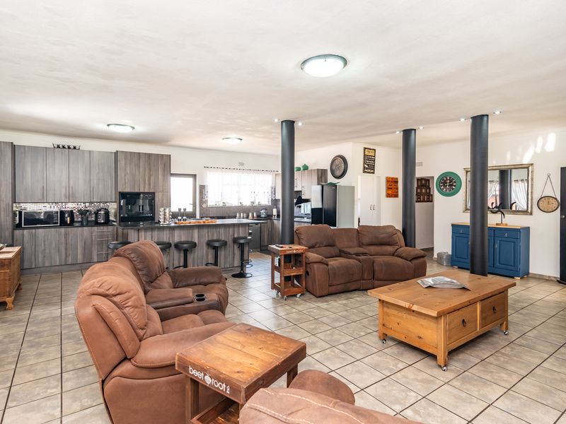 Spacious open-plan living area featuring a modern kitchen with built-in cabinetry, a central island, and tiled flooring throughout.