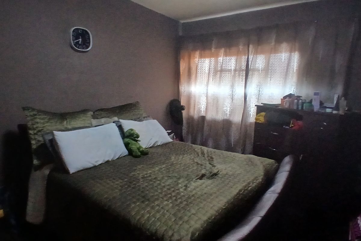 A standard bedroom featuring neutral wall finishes and window treatments, offering a functional space for rest.