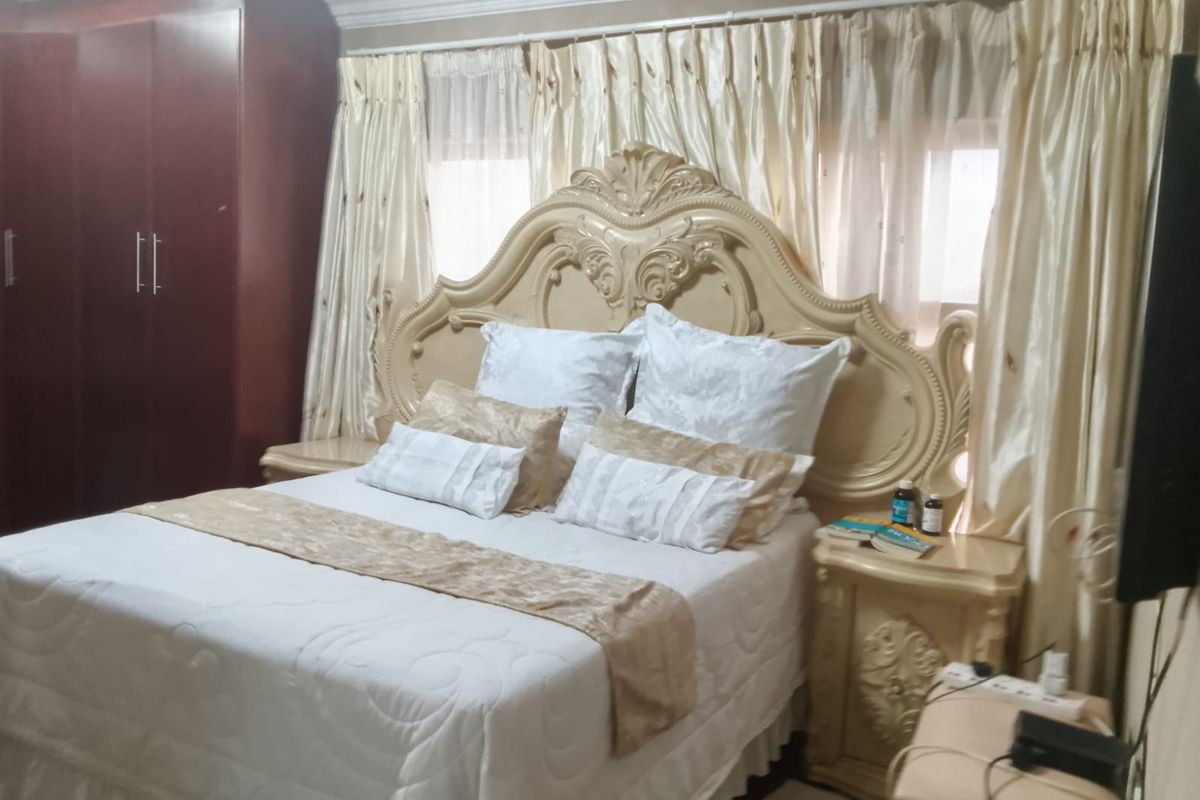 A bedroom featuring a built-in wardrobe and decorative crown molding, providing a functional space with traditional design elements.