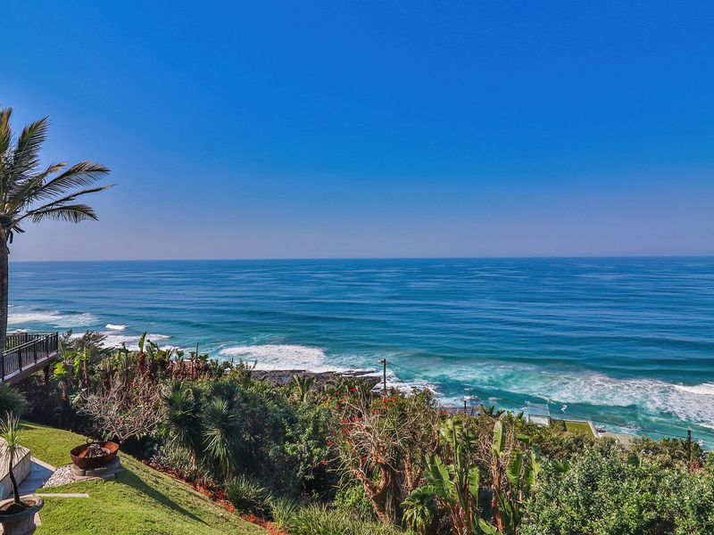 Stunning elevated ocean view overlooking the coastline, featuring a well-maintained garden and a covered balcony area.