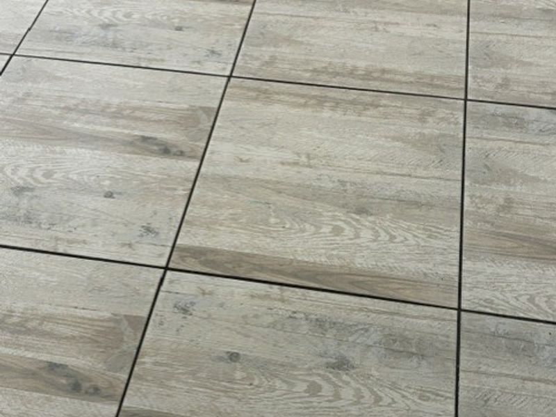 Close-up view of modern wood-look ceramic floor tiles with a neutral finish.