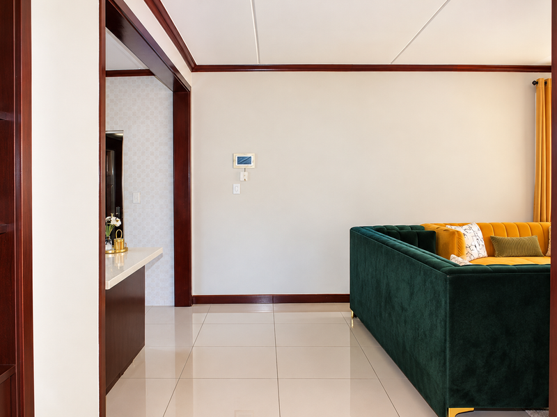 A well-maintained living area featuring polished tile flooring, dark wood trim, and built-in shelving, creating a clean and structured interior space.