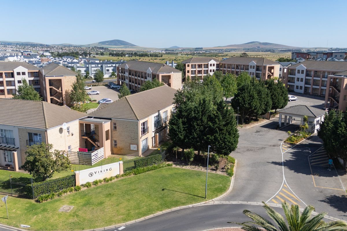 Aerial view of the Viking complex, showcasing multiple apartment blocks, paved driveways, security entrance, and well-maintained communal garden areas.