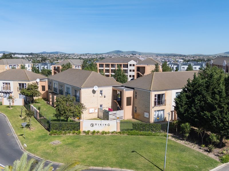Aerial view of the Viking Villas apartment complex, showcasing the building architecture, landscaped grounds, and surrounding residential neighborhood.