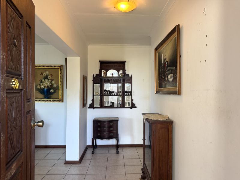 Entrance foyer featuring tiled flooring and a solid wood front door, leading into the main living area.
