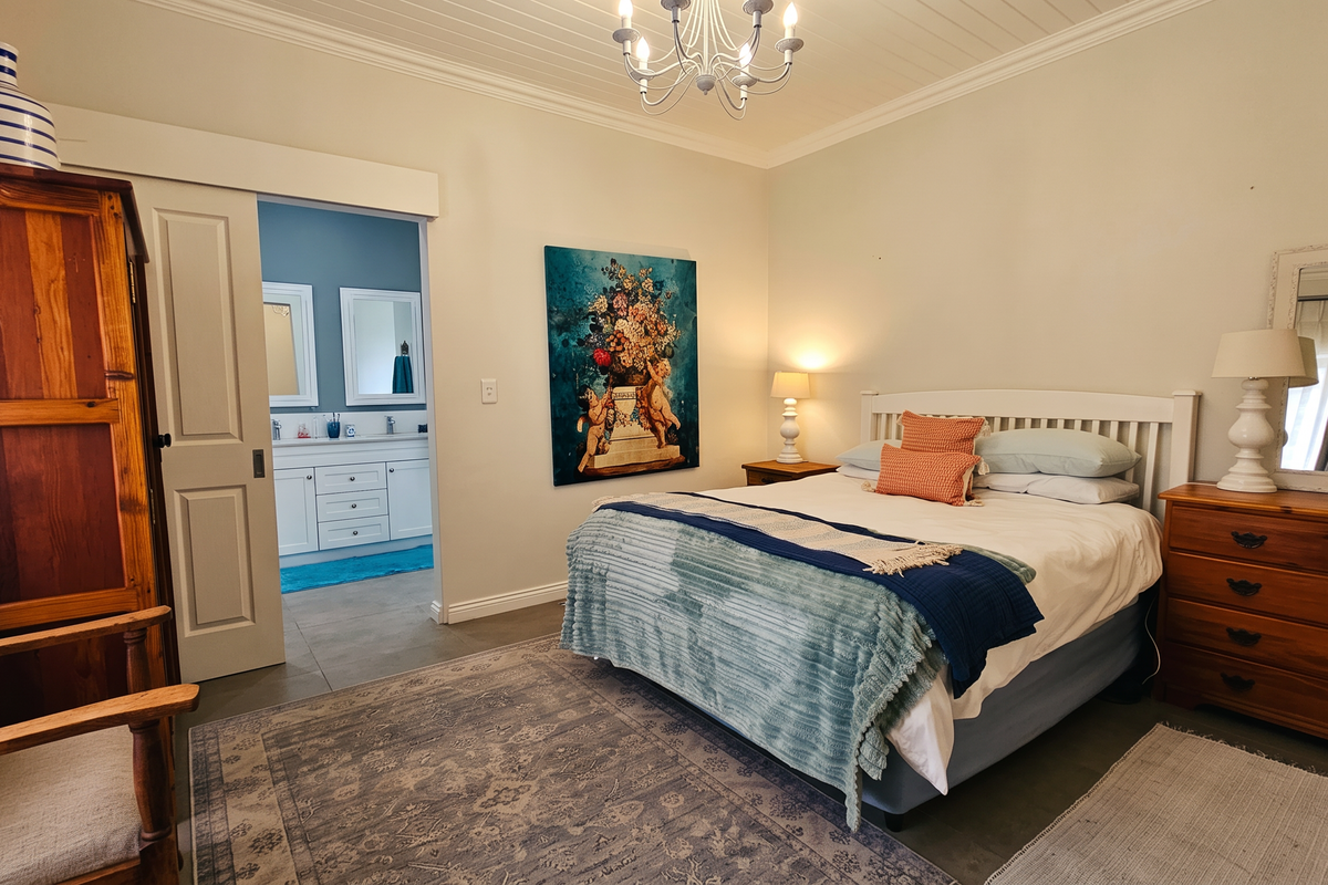 Spacious bedroom featuring a tongue and groove ceiling, cove cornice, and direct access to an en-suite bathroom through a sliding door.