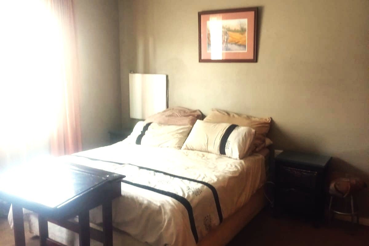 A standard bedroom featuring neutral wall paint, coving, and a ventilation grille, providing a functional space for rest.