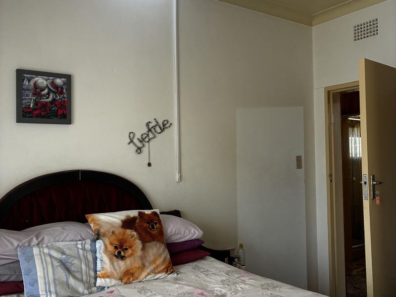 A standard bedroom featuring neutral walls, a ceiling vent, and an internal door leading to an adjacent space.
