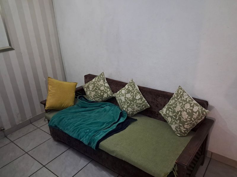 A living area featuring tiled flooring and a combination of plain and striped wallpaper finishes.