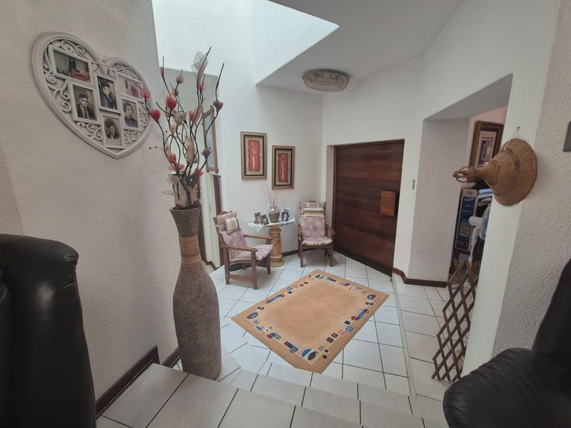Bright entrance foyer featuring tiled flooring, a solid wood front door, and a large skylight providing natural illumination to the space.