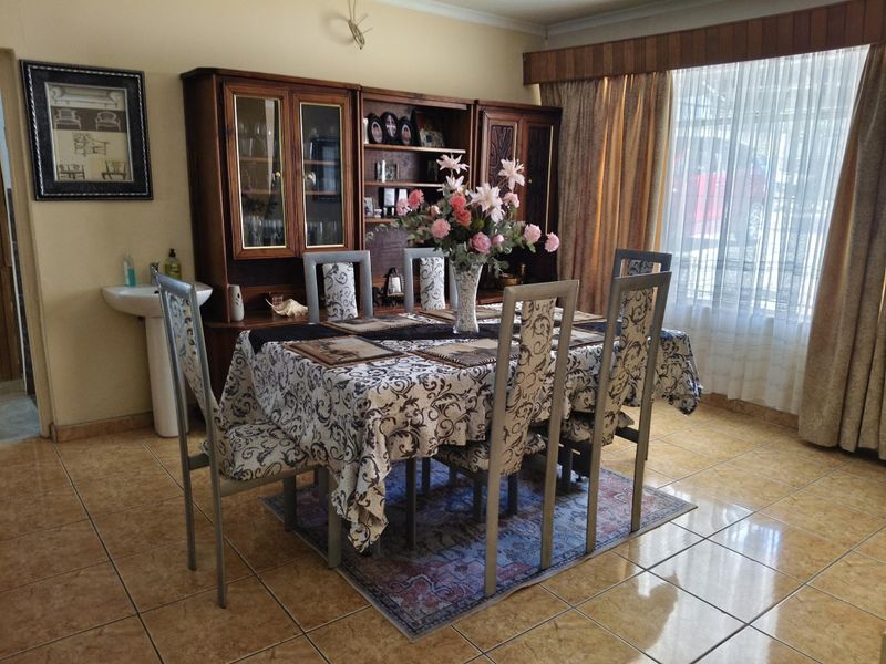 A dining room featuring tiled flooring and a built-in pedestal basin, offering a functional space for family meals.