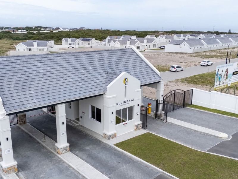 Aerial view of the Kleinbaai Lifestyle Estate security entrance gatehouse featuring paved access lanes and perimeter fencing.