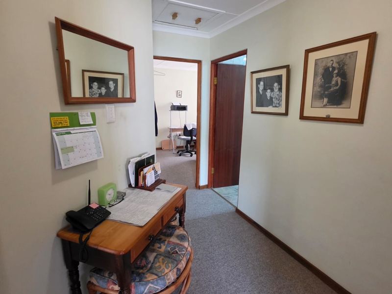 A functional hallway featuring carpeted flooring, coved cornicing, and access to adjacent rooms through timber-framed doorways.