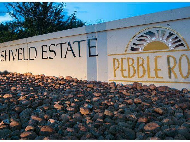 Entrance signage for Pebble Rock Golf & Bushveld Estate, featuring a decorative boundary wall and landscaped rock garden.
