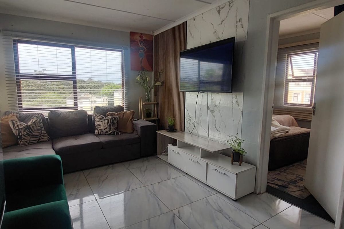 Living room featuring marble-effect floor tiles, a slatted wood accent wall, and a marble-effect media wall panel with integrated television.