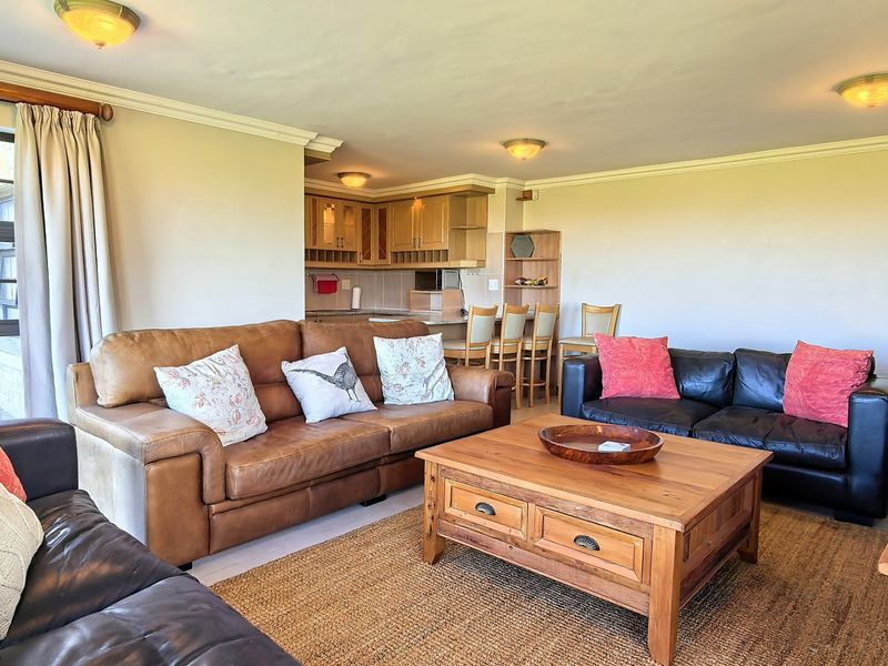 Open plan living area featuring a combined lounge and kitchen space with built-in cabinetry and a breakfast bar.
