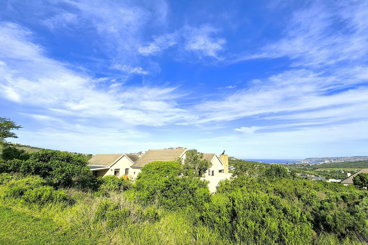 An elevated view of the property nestled within a landscaped coastal environment, showcasing the roof structure and surrounding natural vegetation.