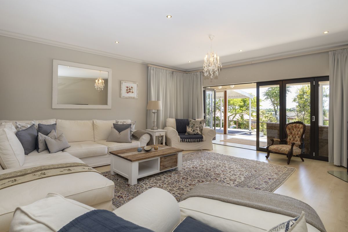 Spacious living room featuring laminate flooring, recessed lighting, and large sliding glass doors that open onto an outdoor patio area.