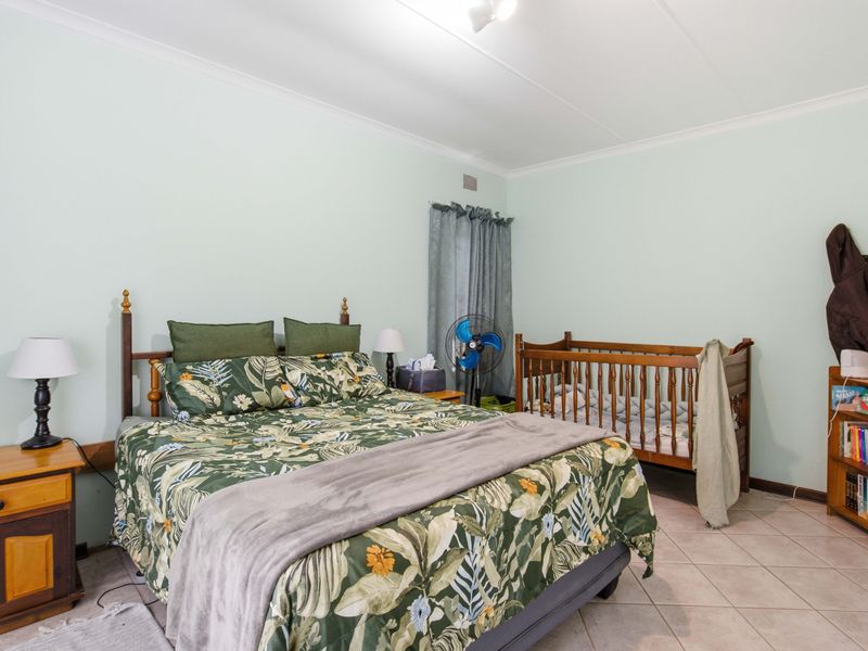 A spacious bedroom featuring neutral wall finishes and durable tiled flooring, providing a functional and versatile living space.