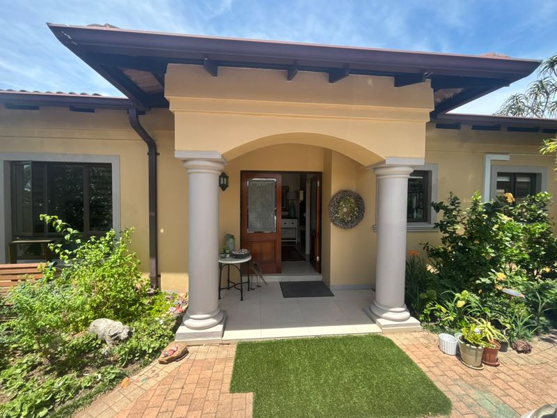 A welcoming front entrance featuring a covered porch with decorative columns, tiled flooring, and a timber-framed front door.