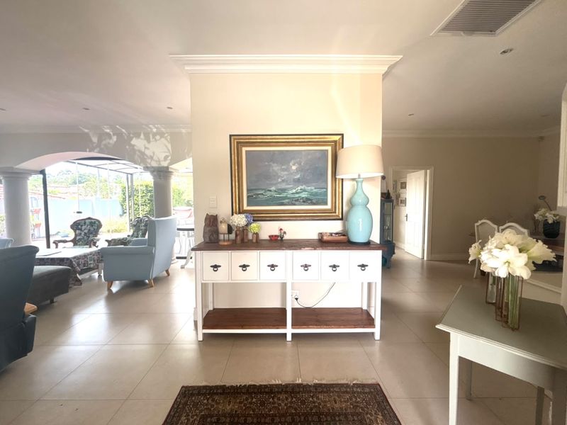 Spacious open-plan living area featuring neutral tiled flooring, crown molding, and recessed lighting, creating a bright and airy atmosphere.