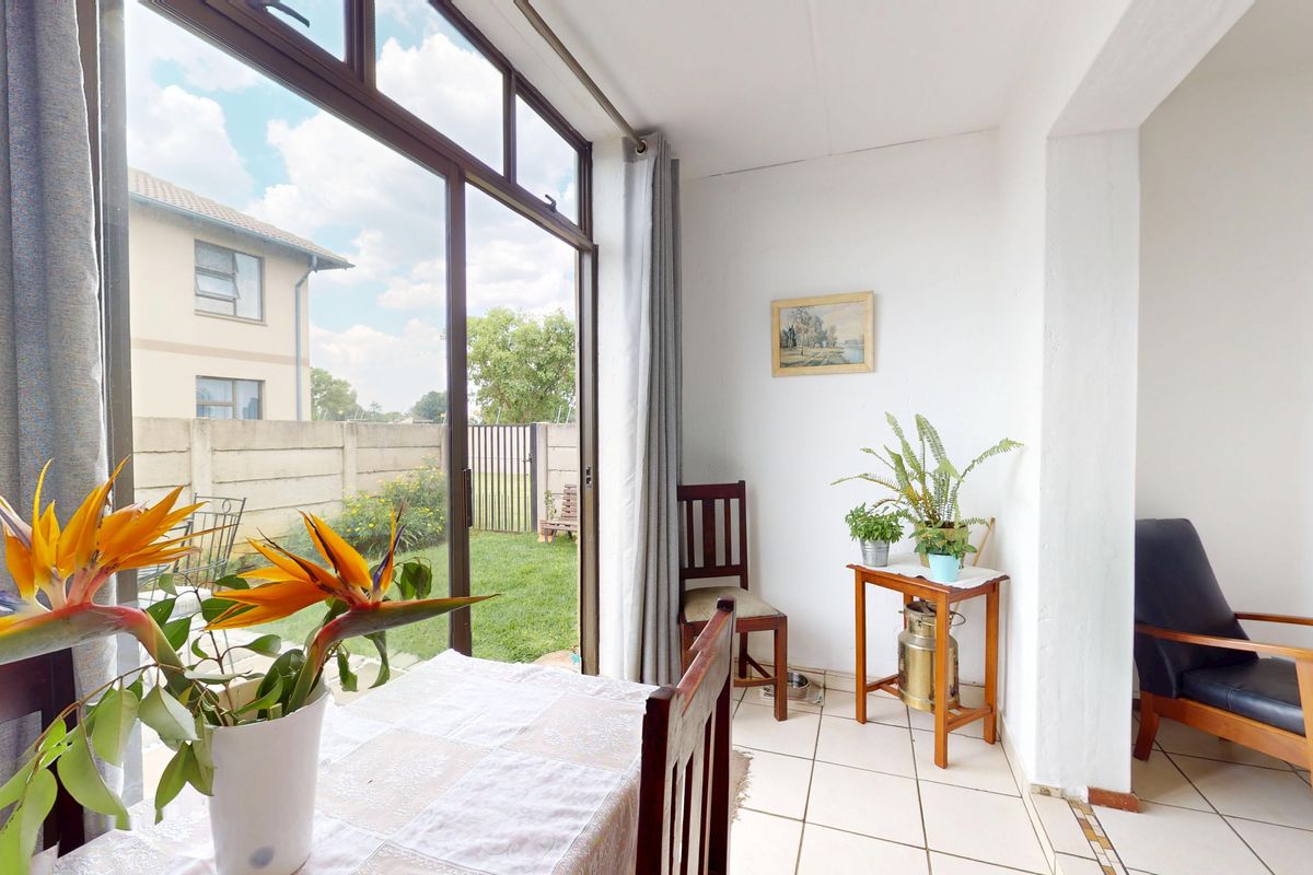 Bright living area featuring large sliding glass doors that provide direct access to the garden and allow for ample natural light.