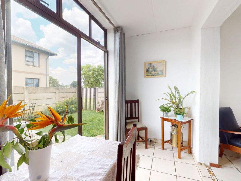 Bright living area featuring large sliding glass doors that provide direct access to the garden and allow for ample natural light.