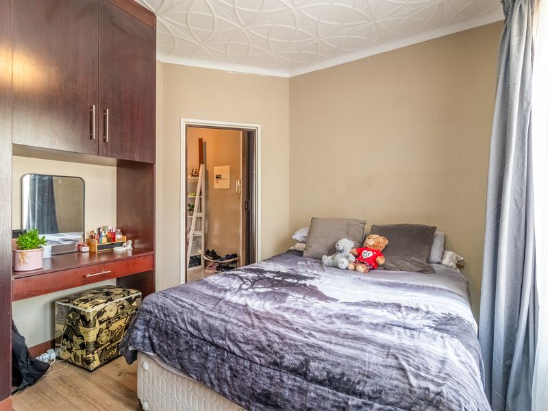 A bedroom featuring built-in cabinetry with an integrated vanity desk and a decorative textured ceiling.