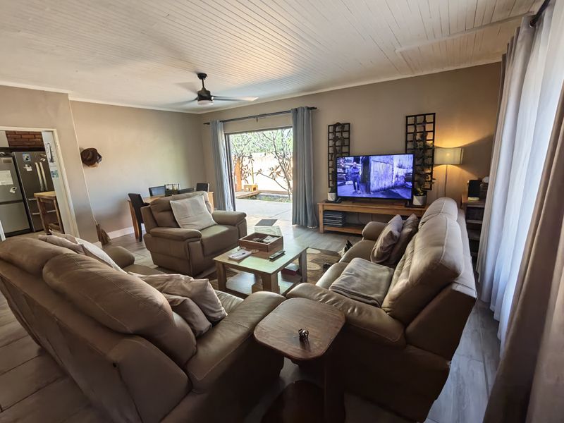 Open-plan living and dining area featuring a tongue and groove ceiling, ceiling fan, and sliding glass doors leading to an outdoor patio space.