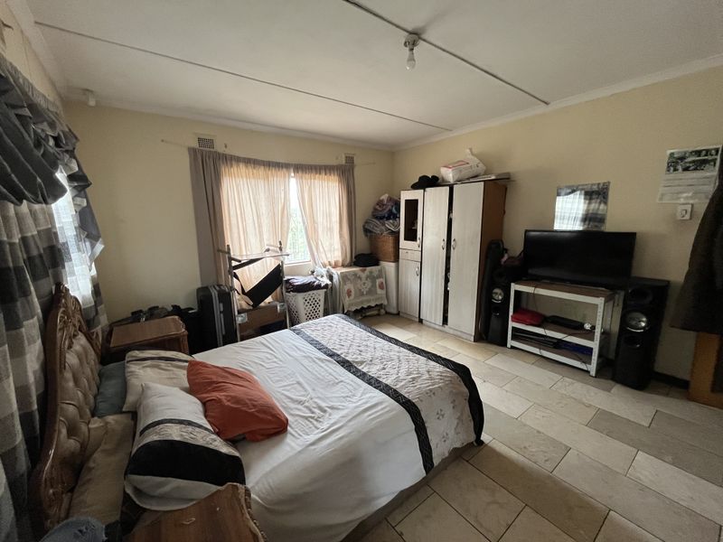 A bedroom featuring tiled flooring and curtain rails, requiring some maintenance to the ceiling panels.
