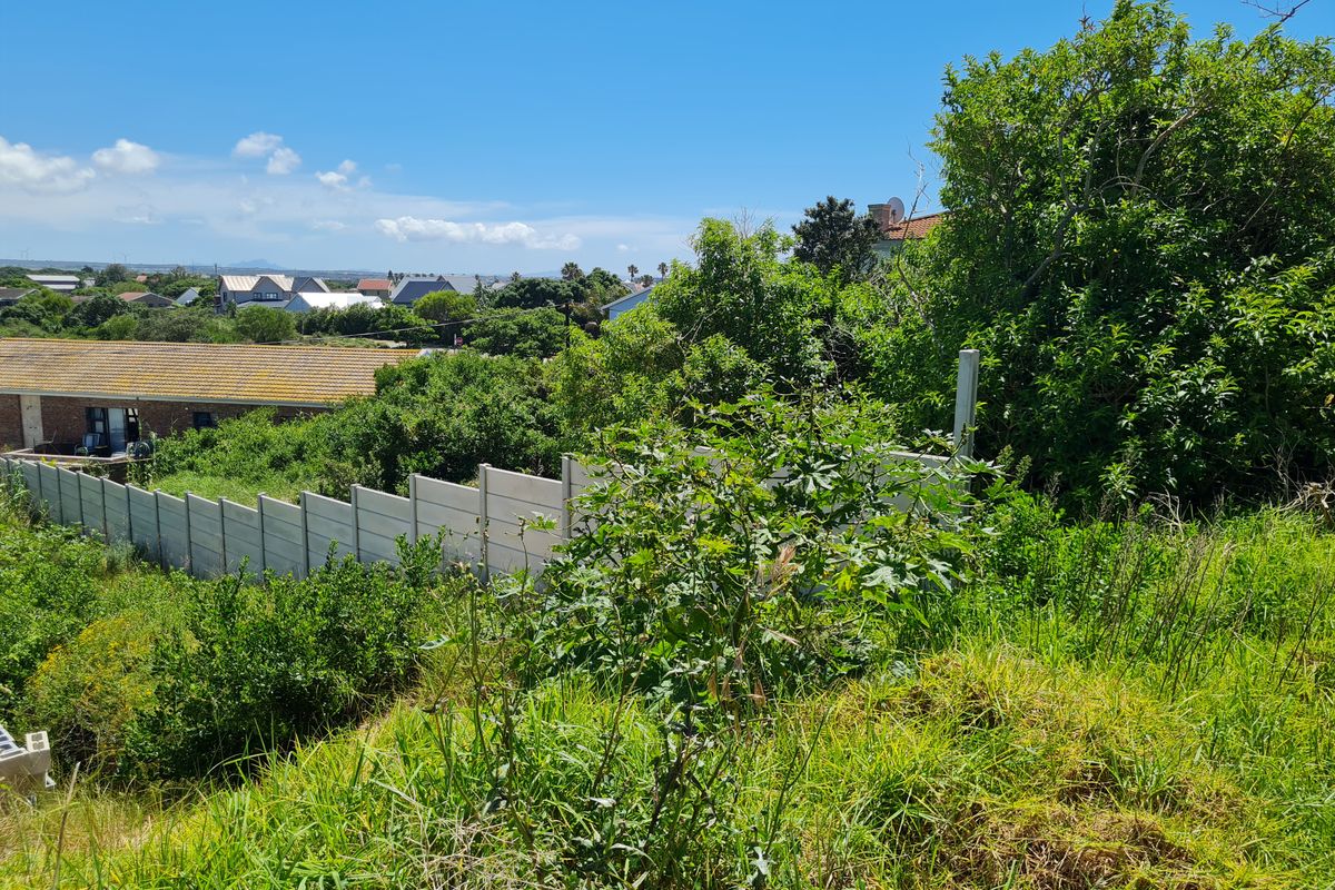 A view of the residential plot featuring a precast concrete boundary wall and surrounding neighborhood landscape.