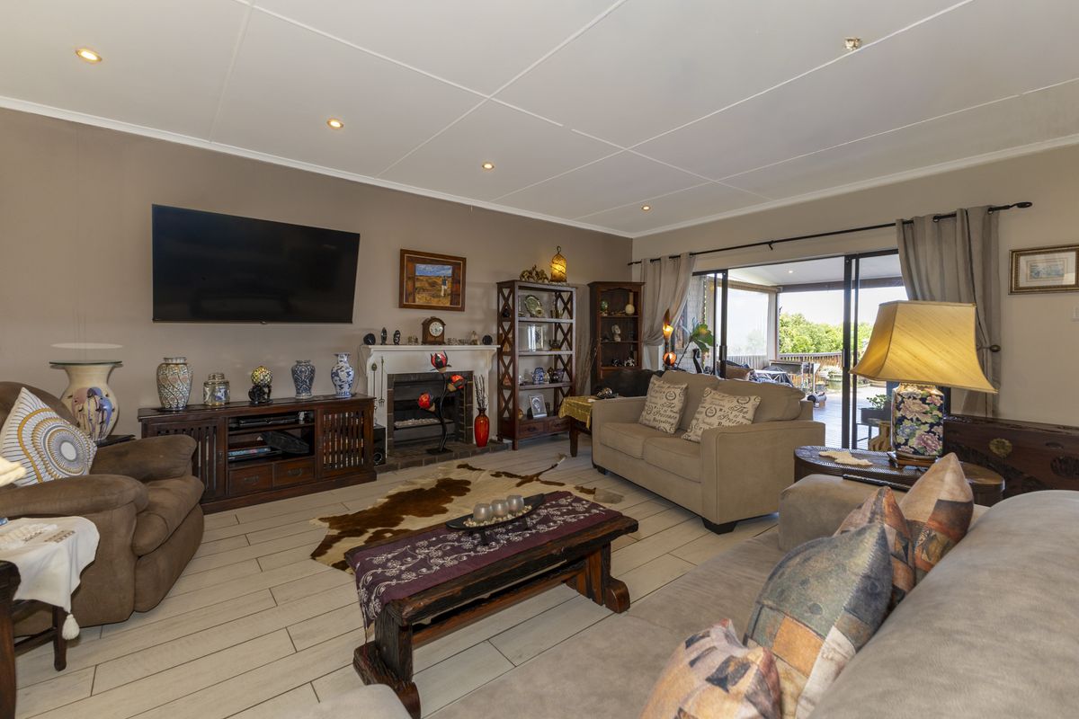 A comfortable living room featuring a fireplace, tiled flooring, and large sliding glass doors that provide access to an outdoor patio area.