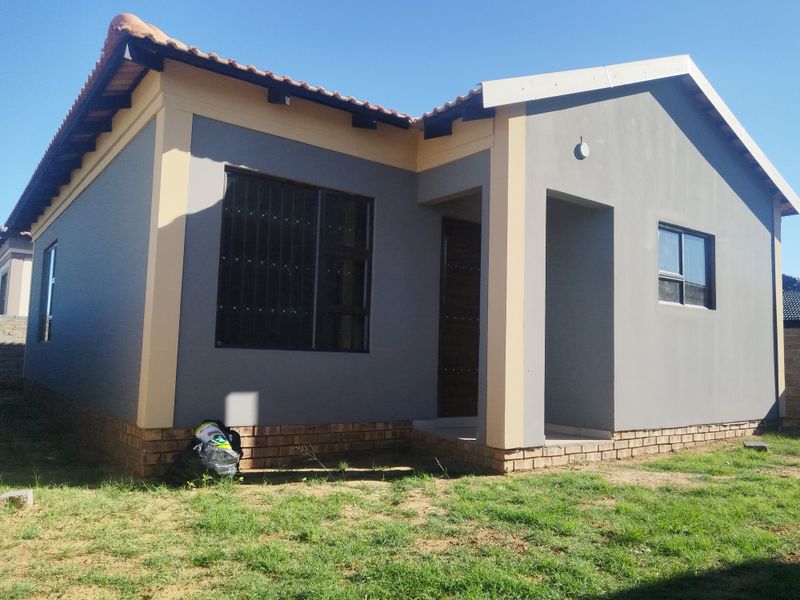 A modern single-story residential house featuring a painted exterior, tiled roof, and security bars on the windows.