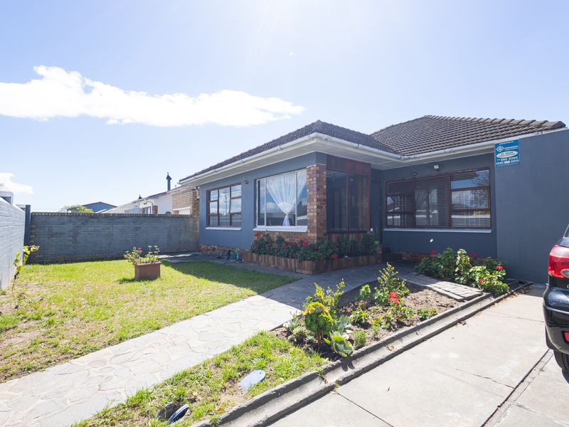 Front exterior view of a house featuring a paved walkway, small garden area, and brick facade details.