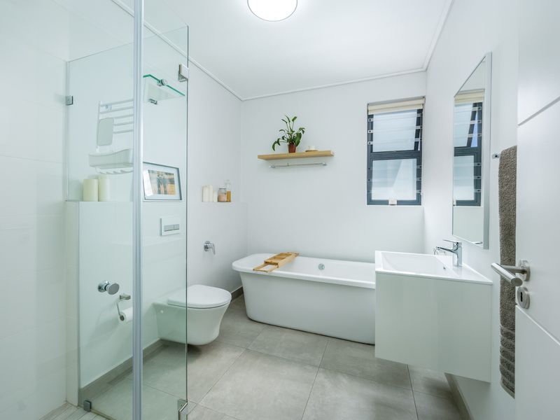 Modern, bright bathroom featuring a freestanding bathtub, glass-enclosed shower, wall-hung toilet, and a sleek wall-mounted vanity with contemporary finishes.