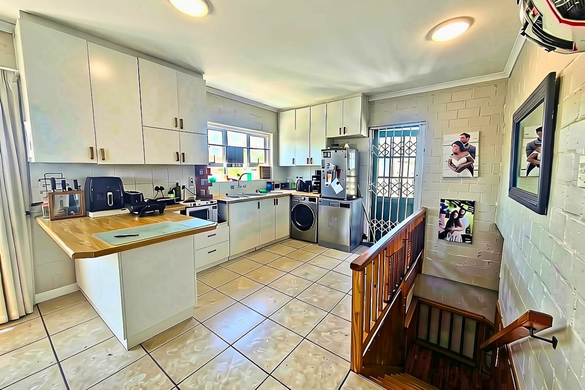Functional kitchen featuring built-in cabinetry, wooden countertops, and tiled flooring, with an adjacent staircase leading to another level.