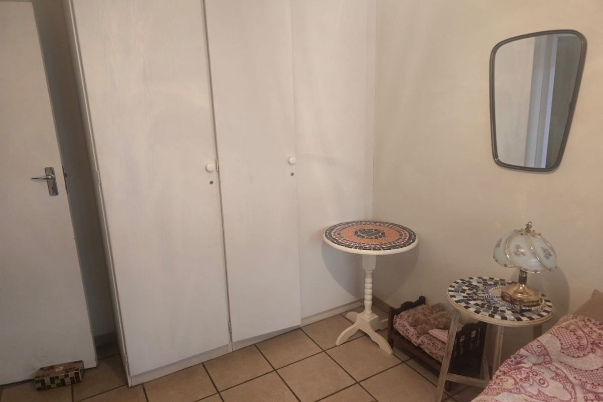 A bedroom featuring built-in cupboards and tiled flooring.