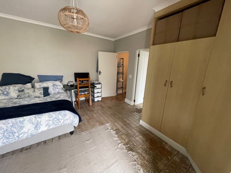 A bedroom featuring tiled flooring, coving, and a large built-in wardrobe providing ample storage space.
