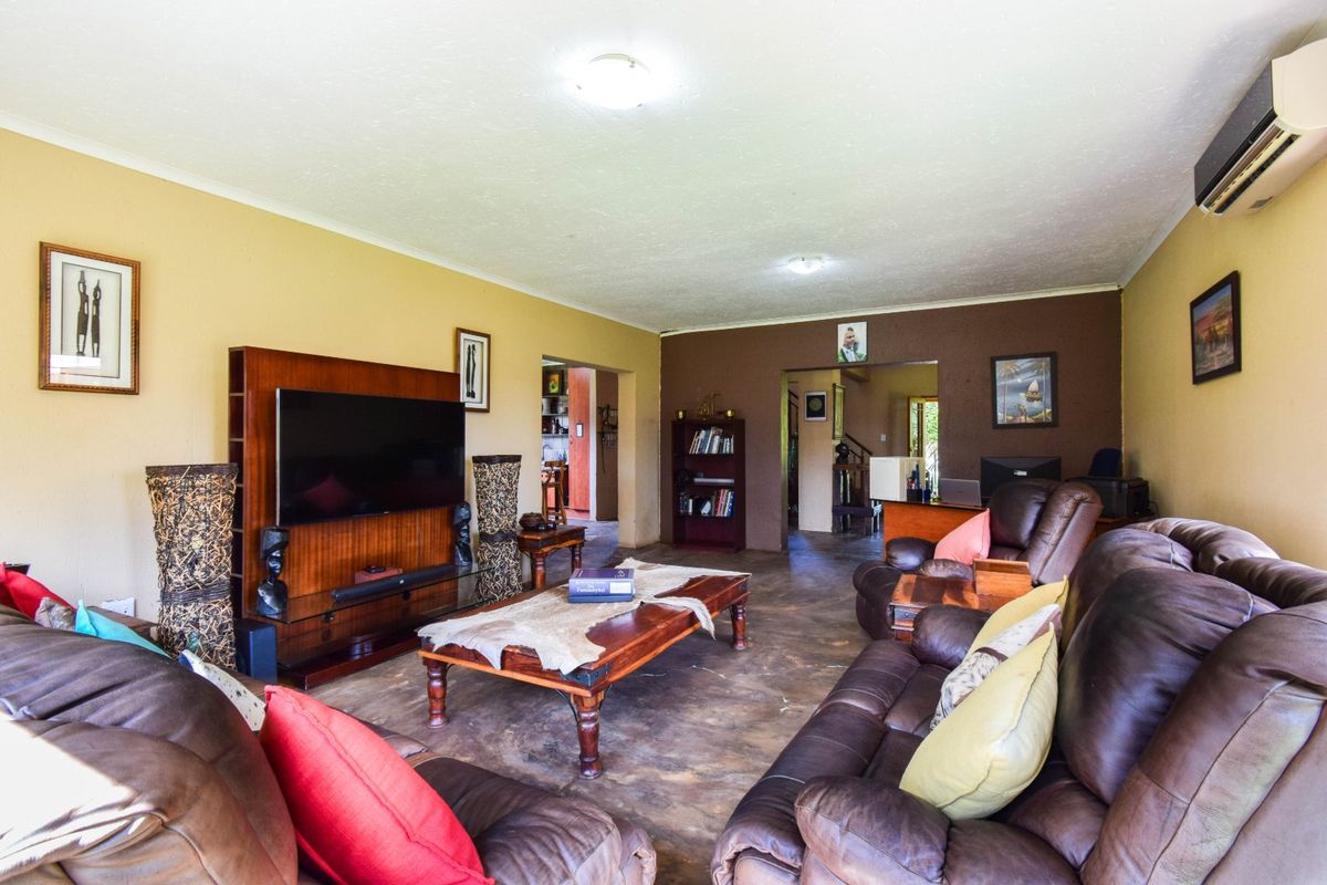 Spacious living room featuring a wall-mounted air conditioning unit and direct access to adjacent living areas.