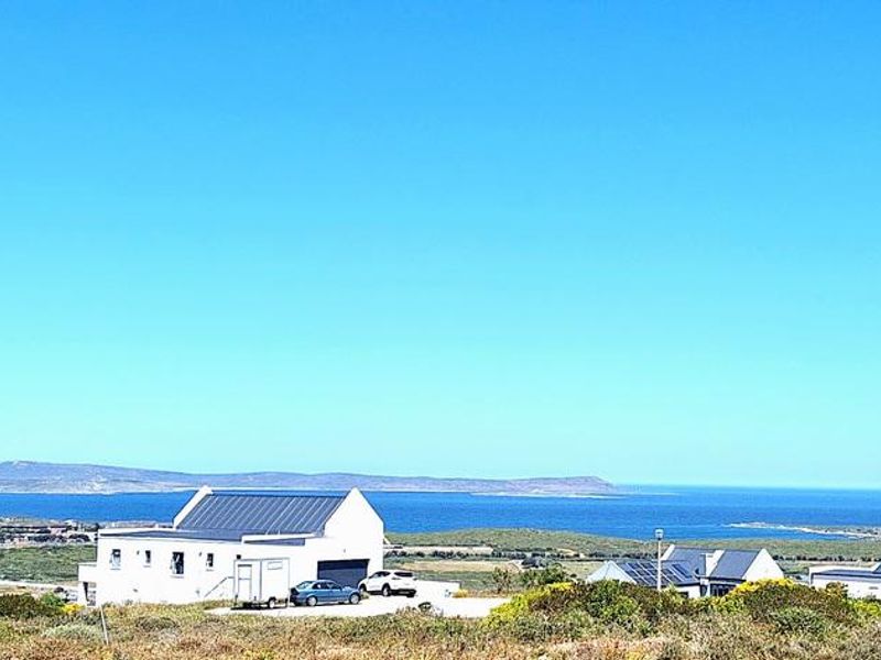 A scenic elevated view overlooking the coastal landscape, ocean, and distant mountains, showcasing the property's expansive outlook.