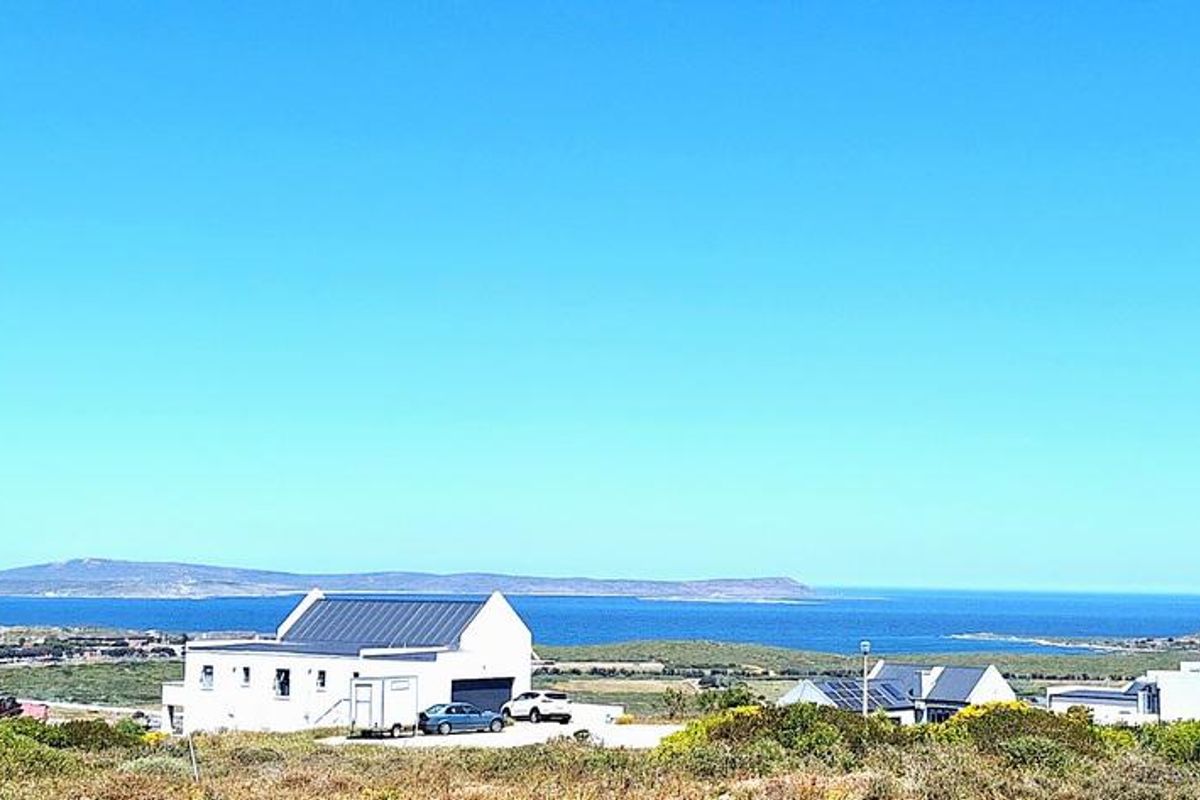 A scenic elevated view overlooking the coastal landscape, ocean, and distant mountains, showcasing the property's expansive outlook.
