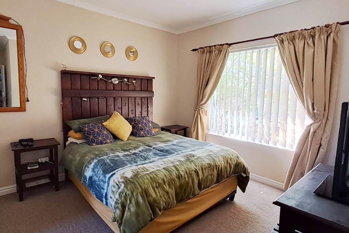 A standard bedroom featuring carpeted flooring, coved ceilings, and vertical blinds, offering a functional space ready for personalization.