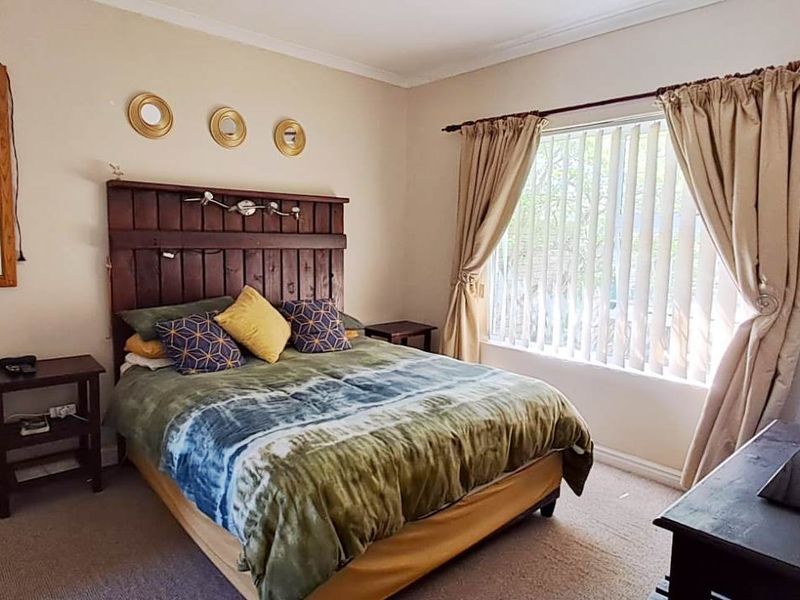 A standard bedroom featuring carpeted flooring, coved ceilings, and vertical blinds, offering a functional space ready for personalization.