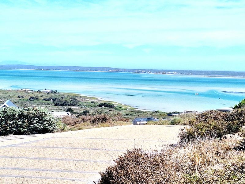 A scenic elevated view overlooking a tranquil coastal lagoon and surrounding natural landscape, showcasing the property's prime location.