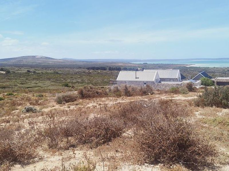 A scenic elevated view of the coastal landscape and surrounding terrain, showcasing the natural environment and nearby residential development.